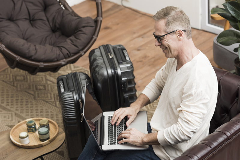Homem lendo dicas de como arrumar as malas para uma viagem.
