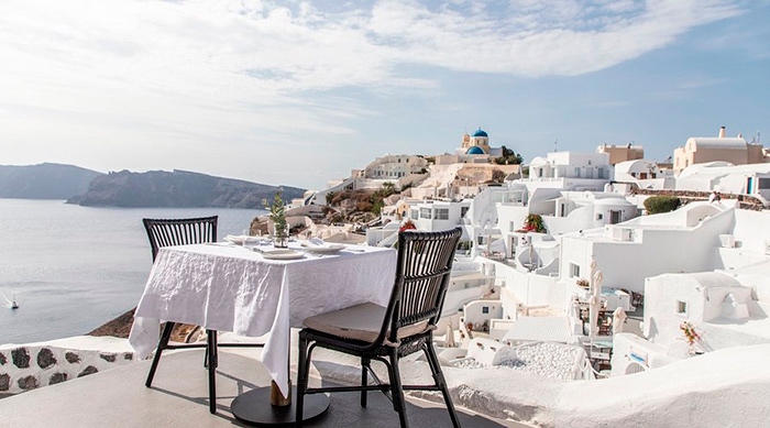 Vista do Mia’s Restaurant em Santorini, Grécia, com mesa voltada para o pôr do sol na Caldeira.