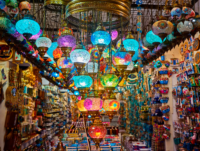 Corredores do Grand Bazaar em Istambul com lojas de tapetes, joias e luminárias típicas.