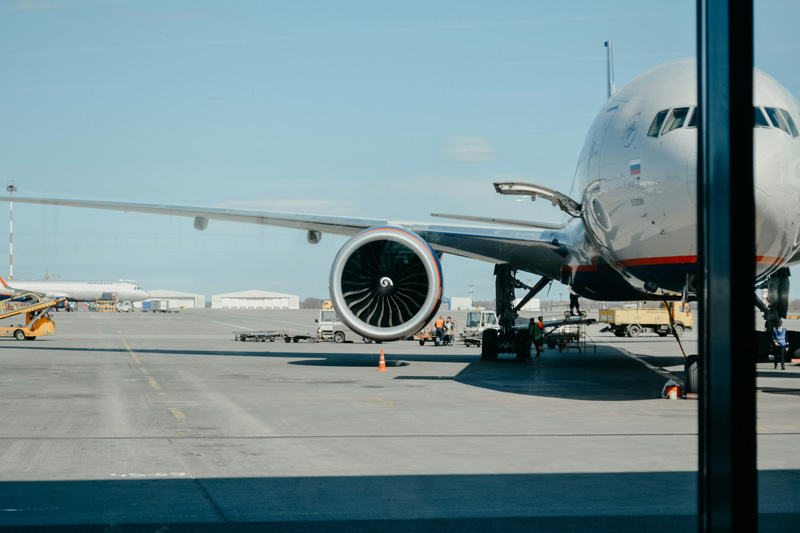Foto de avião em pátio de aeroporto, esperando para levantar voo com passageiros.