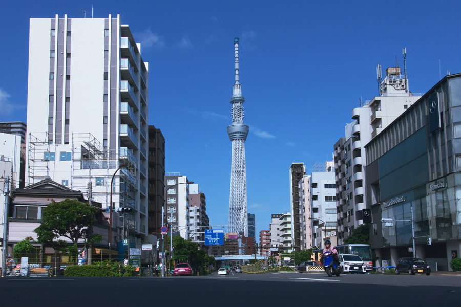 Tokyo Skytree vista entre edifícios urbanos sob o céu azul de Tóquio
