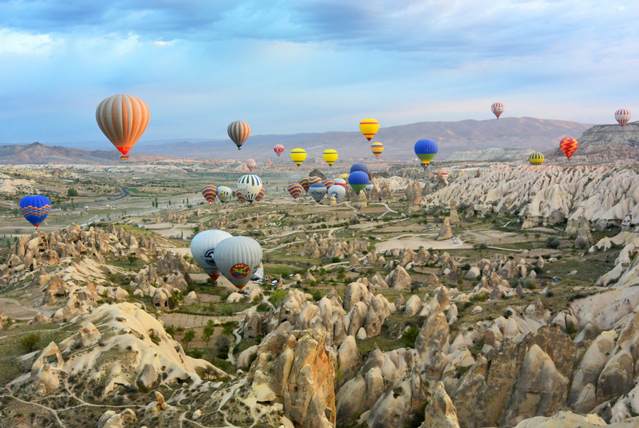 Balões coloridos sobrevoando as formações rochosas da Capadócia, na Turquia, ao amanhecer.