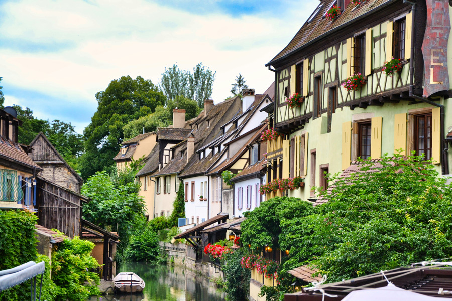 Casas típicas com arquitetura enxaimel e jardins floridos em Colmar, na região da Alsácia, França.