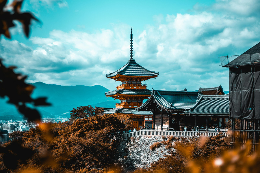 Templo tradicional japonês com telhados característicos e árvores ao redor, em Kyoto, no Japão.