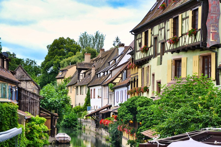 Casas típicas com arquitetura enxaimel e jardins floridos em Colmar, na região da Alsácia, França.