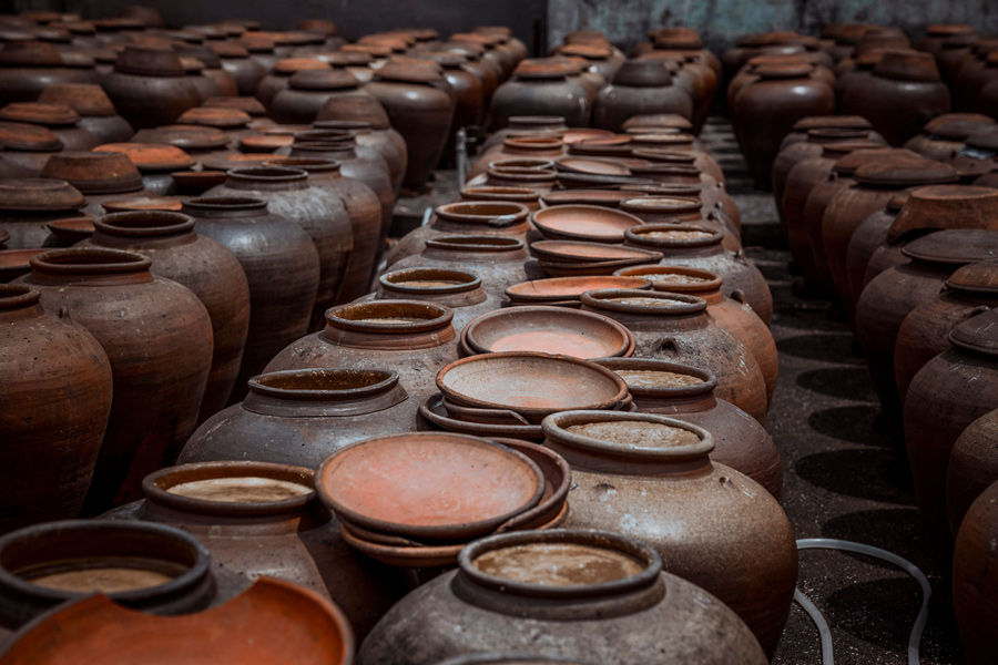 Ânforas de barro qvevri utilizadas no método tradicional de produção de vinho na Geórgia, organizadas em fileiras.